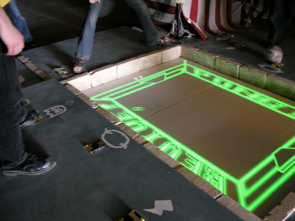 Foot-controlled multiplayer Pong. Played in teams of 2, with one player controlling the paddle and the second player controlling various special effects